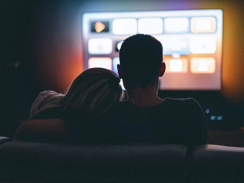 Couple sitting watching television.